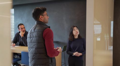 three people looking at whiteboard