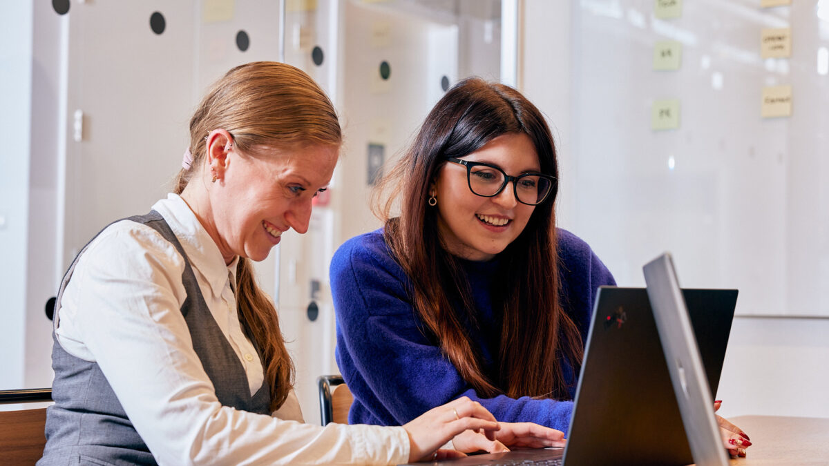 two people working together on laptop