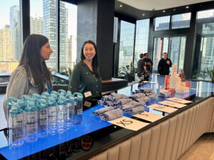 Coworkers standing at table with shirts and water bottles