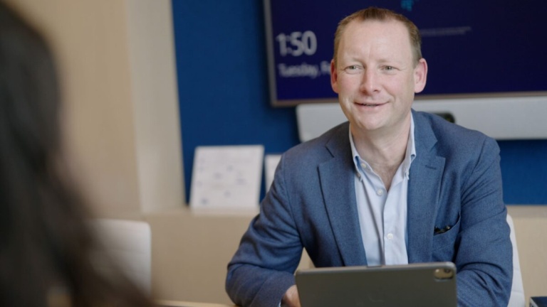 Man in blue sweater smiling