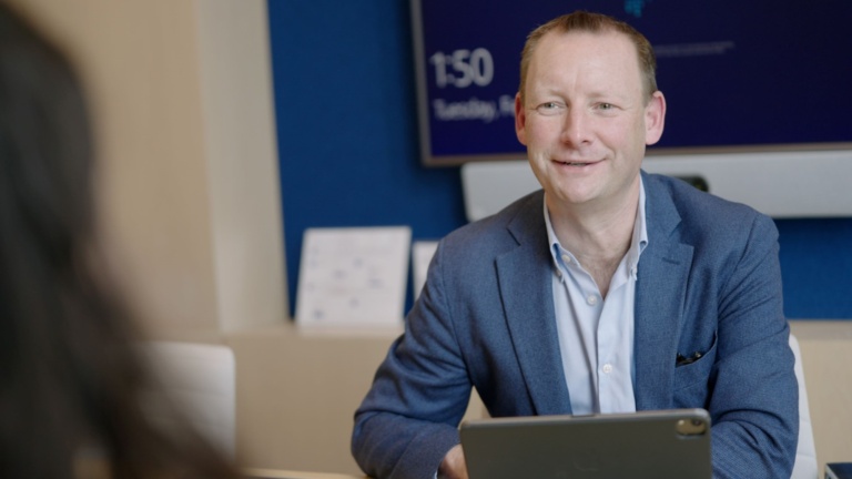 Man in blue sweater smiling