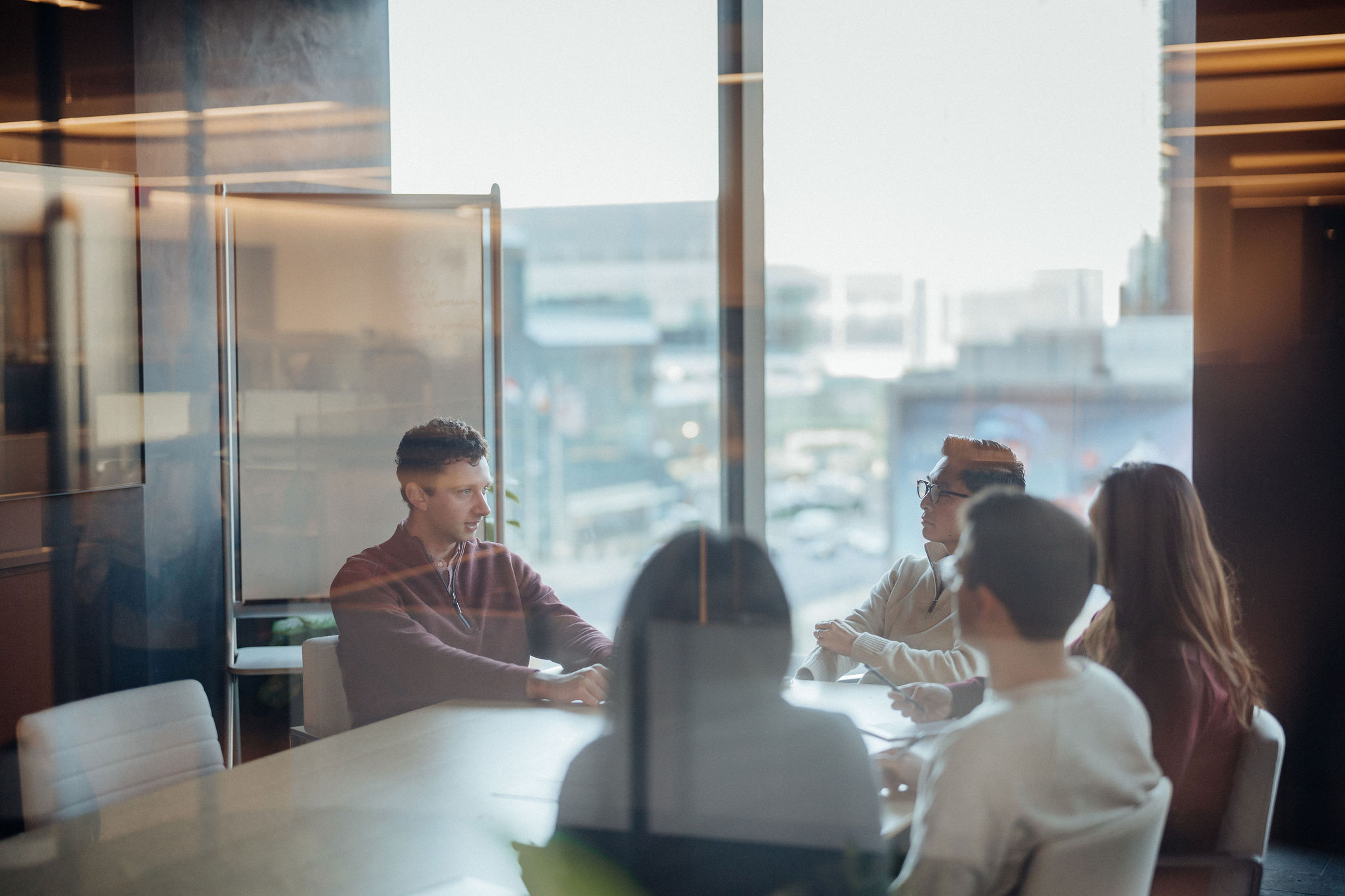 Photo of five people sitting around a table in a conference room